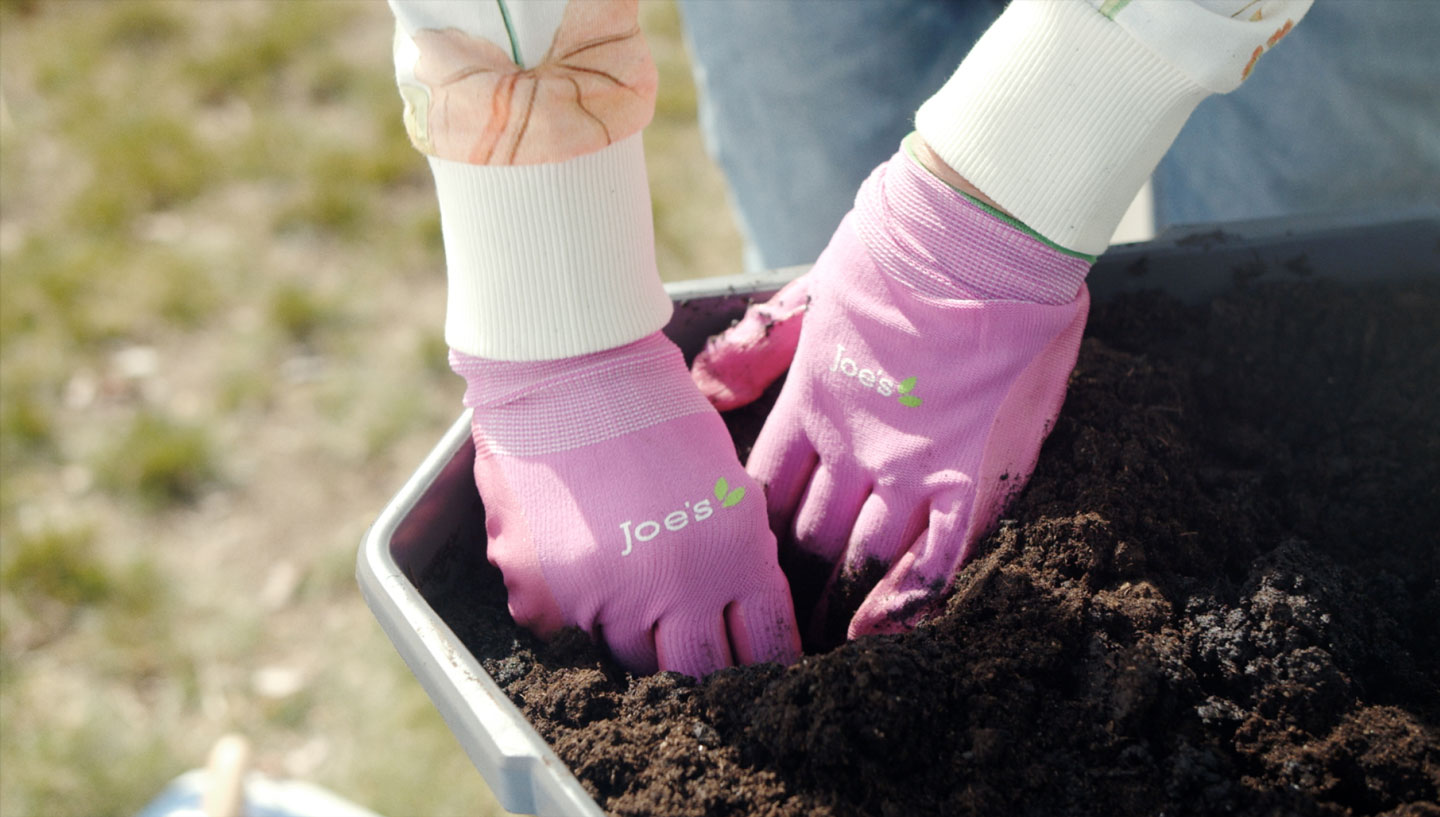 Close up of Amelia's hands as she plants potatoes in the soil.
